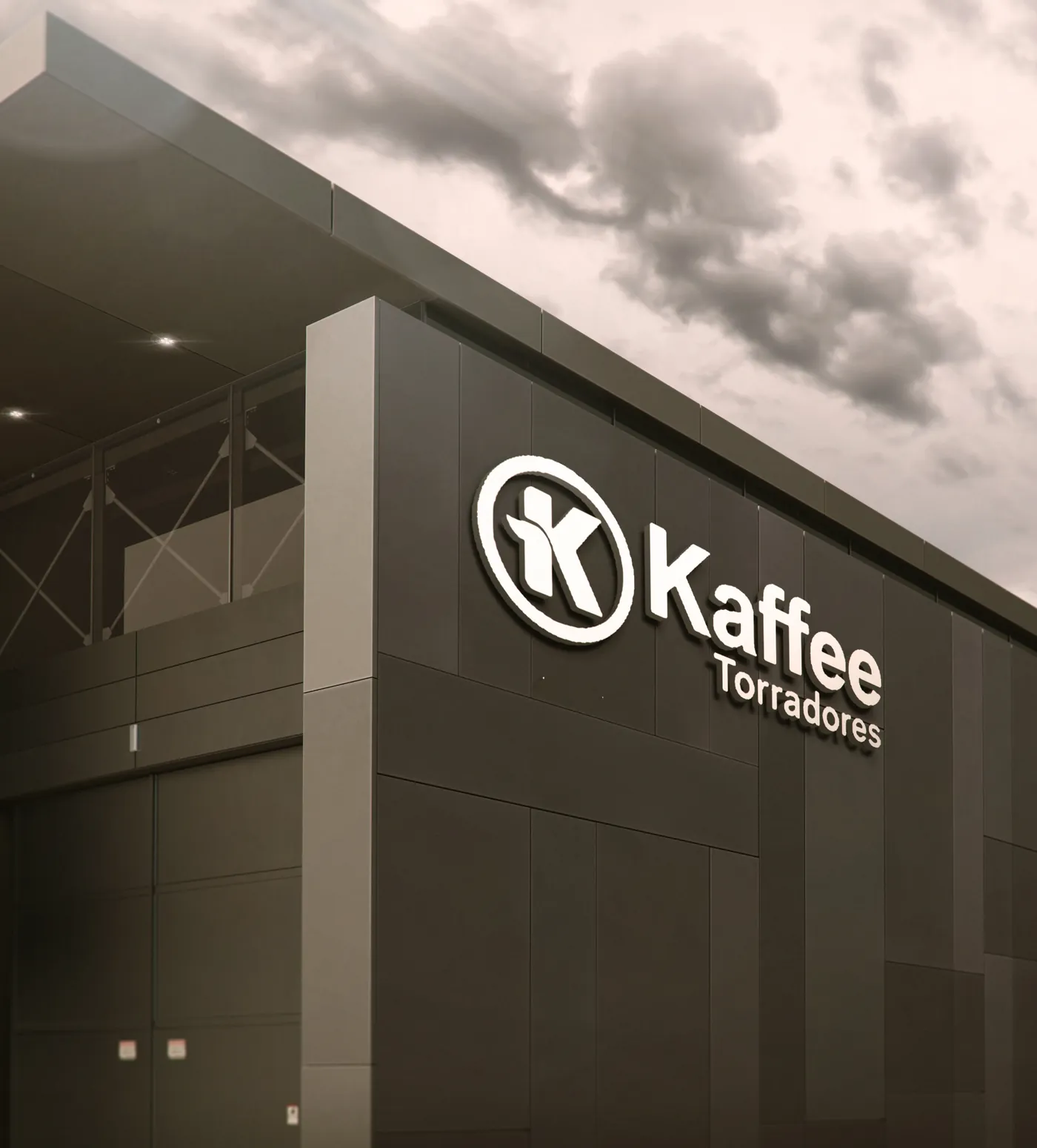 Fachada da fábrica Kaffee Torradores com logo iluminada